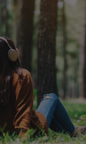 Mujer escuchando audios relajantes en el parque