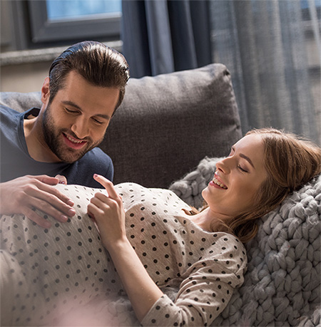 Hombre consintiendo la panza de su esposa embarazada.